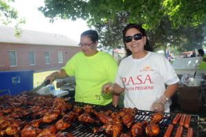 Maria Porter, left, youth program manager from La Esperanza, and volunteer Carmen Garcia keep the grill cooking all day long. BY STEVEN BILLUPS