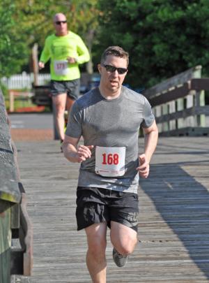 Michael Fraundorfer of Lewes exits the pedestrian bridge ahead of Rehoboth Beach Patrol Capt. Kent Buckson. Both runners finished in just under 22 minutes. BY NICK ROTH