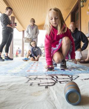 Caroline Hort goes for cargo in the surfman superhero game, while her brother Daemyn watches her moves. Amanda, grandmother Jean Hort and father Bobby look on. BY DENY HOWETH
