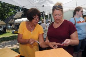 Glass Artist Joan Devaney, left, from Salisbury, Md., helps her customer Dawn Tobiason select the perfect pendant. BY STEVEN BILLUPS