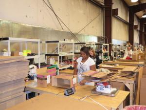 Employees like Long Neck resident Tiffany Moorman prepare items for shipment by Amazon.com out of the E-Revolution warehouses in Selbyville. BY MOLLY MACMILLAN
