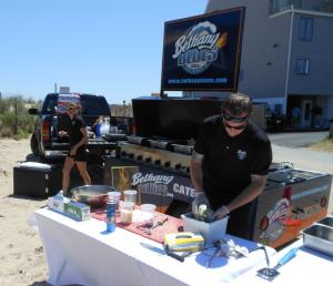 The catering crew from Bethany Blues gets food ready for the lifeguards. Here Bridget Danner runs drinks and food back and forth from the truck, while Mike Rielly prepares a "classic barbeque menu" of smoked pulled pork, macaroni and cheese, baked beans, corn bread and coleslaw. BY CHRIS FLOOD