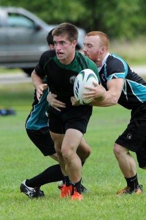 John Haney of the Frederick Rugby Club is pulled from behind by former Cape football player Dean Julian. BY DAN COOK