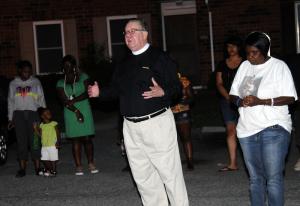 The Rev. Max Wolf of All Saints' Episcopal Church prays for peace within the West Rehoboth community. BY DAN COOK