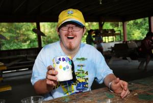 Athlete Geoffrey Steggell proudly displays his flower pot made during arts and crafts activity. BY DAN COOK