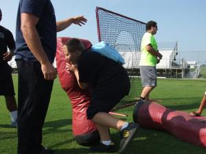 Thomas Hudson, 11, tackles a practice bag after learning the correct way to tackle the dummy by members of the Sussex Tech football team Riley Parker, left, and Jacob Ryan. BY TAGGART HOUCK