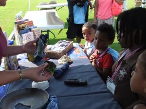Rebekah Legar of the Office of the State Fire Marshal shows burnt toys recovered from a house fire to (l-r) Malcolm Long, Elijah Delgado, Shaila Williams and Ariyanna Johnson. BY TAGGART HOUCK