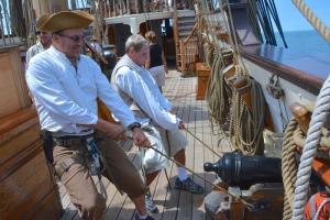 Volunteers Ron Siebach, left, and Ed Molin pull in one of the ship's cannons in preparation for docking. BY RON MACARTHUR