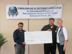 Harry Keswani, left, of the Harry K Foundation, presents his donation to Michael Velazquez, chef of the ESL program, and LaNell Schultheis, program director ESL Program. The Harry K Foundation funds the child care program which runs concurrent with classes and also feeds children pre-school through 12 years of age. SOURCE SUBMITTED