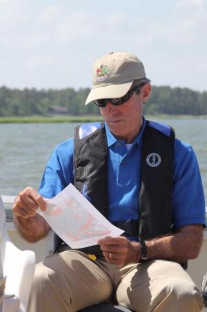 Governor-elect John Carney looks at a map of Inland Bays shellfish aquaculture development areas during a boat tour to one of the sites on Rehoboth Bay in 2015. MADDY LAURIA PHOTO