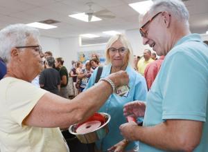 As DHA volunteer Cheryl Buxton wanders through the crowd with raffle tickets, Lin Pagnotta and Bill Marvin take some chances.
