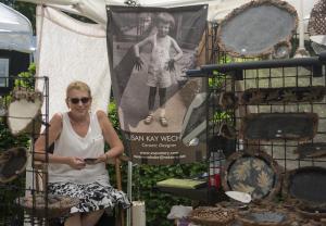 Susan Kay Wechsler sits beneath a photo of herself as a child, and her hands are still in clay.