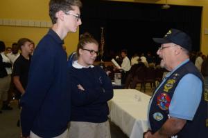 Sussex Academy student Tyler Keeler receives a flag and literature from VFW Post 7234 Commander Dean Levering. CHEER Patriots Day