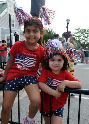 Cousins Riya Mainigi, left, 5, and Layla Walke, 4, take a break from the competition during the annual children's July 4 games. BY DAN COOK