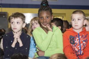 During the Black History Month celebration, (l-r) Dominick Reed, Maddison Daniels and Robert McCann listen intently to storytelling. BY DENY HOWETH