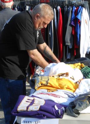Vinny Margherita of Middletown searches through a pile of T-shirts. There were more than 30 vendors at the community yard sale held in the parking lot of the Rusty Rudder this year. BY CHRIS FLOOD