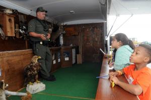 At the State of Delaware Department of Fish and Wildlife trailer, students ask Officer Josh Hudson about the animals seized from poachers by Fish and Wildlife. Shown are (l-r) Hudson, Bianca Garcia-Martinez and Julius Cheers from Fredrick Douglas Elementary. BY STEVEN BILLUPS
