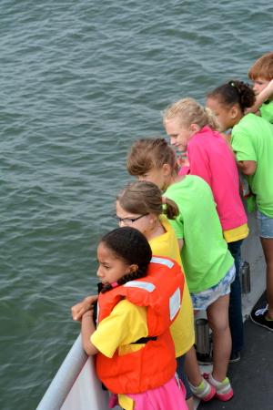 Richard Shields first-graders keep an alert eye out for a break in the water signaling a surfacing dolphin. BY RON MACARTHUR