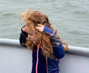 First-grader Shannon McLaughlin has the wind-blown look as she stands in the bow of the boat. BY RON MACARTHUR
