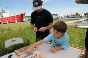 Mark Carter, owner of Quest Fitness and Kayak, event sponsor and organizer, rigs up a line for his son, Sawyer. BY STEVEN BILLUPS