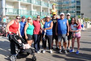 The Reynolds family of (l-r) Erin Baugher with Danny Hillenbrand in stroller, Kevin Hillenbrand, Ashley Reynolds, Jenny Reynolds Matta, Lily Reynolds, JoAnn Reynolds, Mark Reynolds with Summer Reynolds on shoulders, Jim Reynolds, Doug Reynolds, and Ashlee Moore with Shayne Reynolds await the start of the Dave Reynolds Swim & Run Biathlon. BY DAN COOK