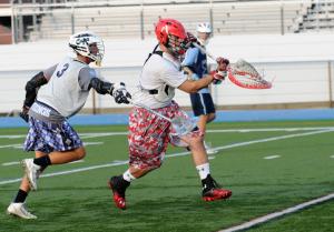 Former Cape All-American and Lynchburg College goalie James Cook clears the ball with Cape rising senior Jeb Monigle in pursuit. BY DAN COOK