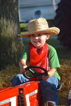 Chapel Divers, 4, visiting the fair with his family from Virginia, takes a ride on a pedal tractor. BY RON MACARTHUR