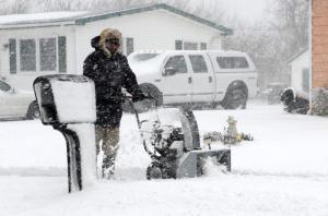 Near white out conditions can’t keep this Mulberry Street resident from using his snow blower to clear the sidewalk. DAN COOK PHOTO