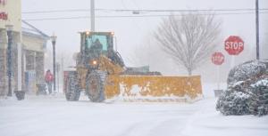 In a scene that will be repeated many times this weekend, a front-end loader moves snow off the parking lot in the Weis parking lot in Lewes. RON MACARTHUR PHOTO