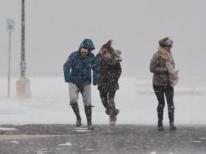A trio brave the cold wind as they try to walk across the road toward Lewes Beach. RON MACARTHUR PHOTO