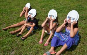 Addison and Tanner Elliott and Maggie and Anna Dauphin, visiting their grandparents in Lewes, view the eclipse during an event at Lewes library. RON MACARTHUR PHOTO