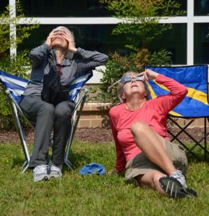 Barbara Kelly, left, and Ann McNeil, both of Lewes, couldn’t keep their eyes off the astronomical wonder unfolding before them. RON MACARTHUR PHOTOS