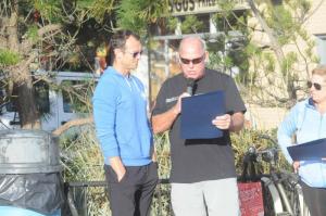 Rep. Pete Schwartzkopf reads a proclamation for Steve “Monty” Montgomery, thanking Monty for the thousands of dollars he raised in the Dewey Goes Pink event. Accepting the proclamation for Monty is Adam Howard of the Body Shop. Puerto Rico 5K