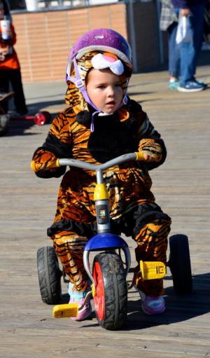 Little tiger Lila Fucci of Wilmington is ready to ride in the tyke bike roll Friday afternoon on The Boardwalk. RON MACARTHUR PHOTO