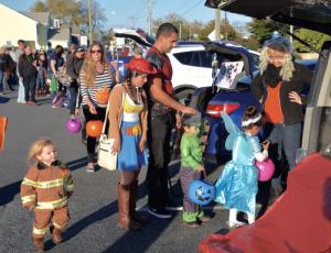 Costumed children – and some parents – line up Friday to get candy during truck and treat at Sussex Family YMCA. RON MACARTHUR PHOTO