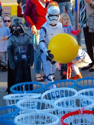 As a little Darth Vader looks on, a little Star Wars storm trooper takes a shot at hitting a basket as he plays one of the games at the Sussex Family YMCA. RON MACARTHUR PHOTO