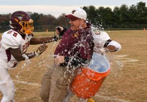 Milford defensive coordinator Tim Fisher gets a sideline shower compliments of Rahshawn Price, left, and Mardis Powell.