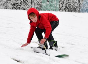 Conor Quigley, 8, of Milton gets quality rides on his snowboard at the Chandler Street hill. DAN COOK PHOTO