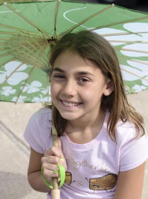 Maile Godwin shades herself with a green parasol.