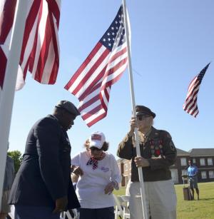 Shayne Brittingham escorts Rita D’Ascenzo and Tom Creekmore, a WW2 radio operator on a B-17 bomber to dedicate the flag in honor of the Greatest Generation of WW2.