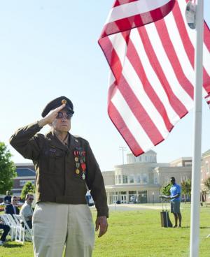 WW2 radio operator Tom Creekmore salutes the flag after dedication it to the Greatest Generation of WW2.