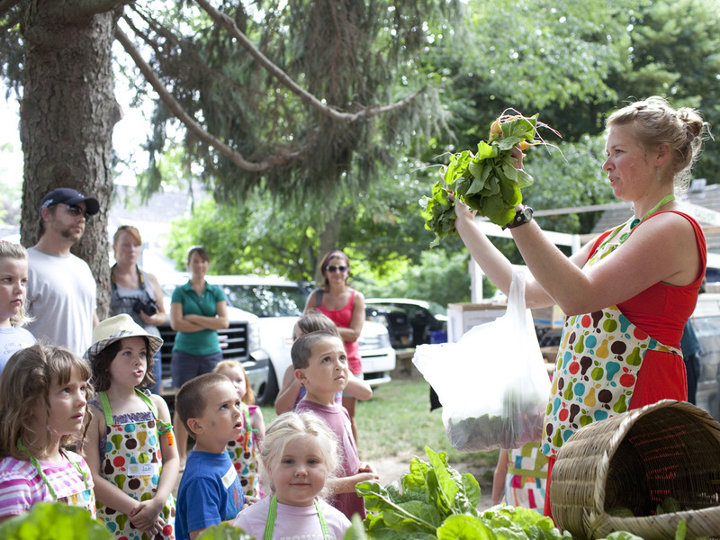 In the foreground from left, Lainey Shockro, Jade Carter (with hat), Dalen Daminger and Owen Daminger watch intently as Katie Freer holds up a bundle of radishes from Calliope Farms of Salisbury, Md., to be used in the recipe of the day, while Sienna Jacona takes a moment to smile at the photographer during a Sprouting Chefs demonstration. SOURCE SUBMITTED