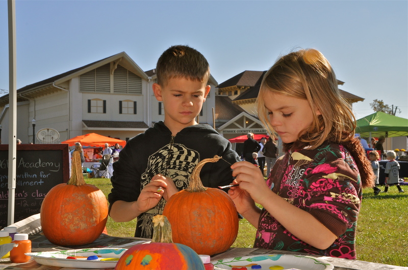 Jack Remmel, left, and sister Una of Marriottsville, Md., paint Halloween pumpkins at a booth sponsored by John Milton & Co. BY RON MACARTHUR