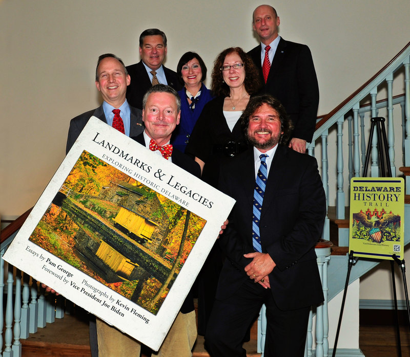 Celebrating the kickoff of the Delaware History Trail are in back (l-r) Gov. Jack Markell, Delaware Economic Development Office Director Alan Levin, Delaware's Director of Tourism Linda Parkowski, writer Pam George and Secretary of State Jeffrey Bullock. In front holding "Landmarks and Legacies" is photographer Kevin Fleming with historian Russ McCabe. SOURCE SUBMITTED