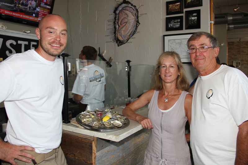 Joe Baker of Henlopen City Oyster House, left, and Barbara and Ted Nowakowski of Broadwater Oyster Company show off a dozen Broadwater oysters on the half shell. The oysters were featured during a happy hour on Monday, July 16, to celebrate the first anniversary of Broadwater's entry into the Rehoboth Beach market, at Henlopen City Oyster House. BY DENNIS FORNEY