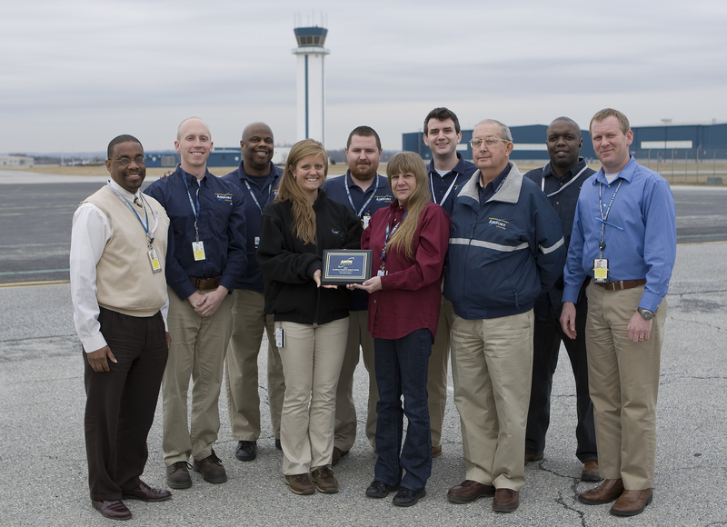 Wilmington – New Castle Airport’s (ILG) airfield operations staff proudly display their ANTN Digicast Excellence in Airport Training Award on the apron near the terminal building. Pictured from left to right are Steve Williams, Ryan Adams, Ron Riley, Tabatha Ialacci, Jason Steele, Vicki Keatts, Jason Gass, Albert Dohring, Moses Nanga, and Ben Clendaniel. BY DRBA