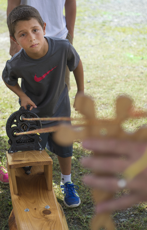 Josh Wright, 8, is very serious about cranking the rope-making machine, made by John Chirtea and run by Miki and Sue Mathe. BY DENY HOWETH