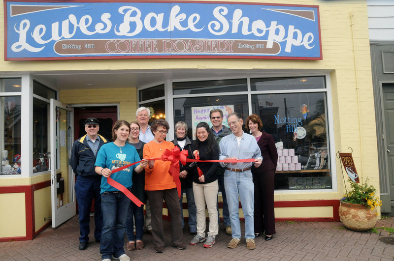 Notting Hill Coffee Roastery-Lewes Bake Shoppe cut a ribbon celebrating its 25th Anniversary in a ceremony sponsored by the Lewes Chamber of Commerce. Shown standing in the back are (l-r) Fred Beaufait, city councilman; Ted Becker, deputy mayor; Bonnie Osler, city council; Mayor Jim Ford; and Betsy Reamer, Lewes Chamber executive director. In front are Bake Shoppe employees Sarrah Gerrick; Suzi Jamgochian; Marlene Bradley; Amy Felker, owner; and Stuart Vining, Felker’s singing partner. BY STEVEN BILLUPS