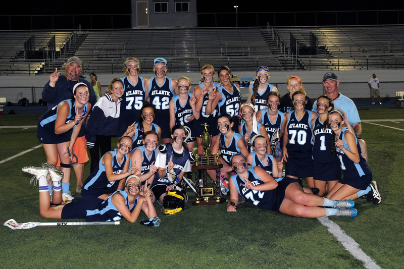 The Atlantic Lacrosse U15 girls' squad defeated Queen Anne's 14-8 to win the championship trophy Tuesday, May 19 at Legends Stadium. Shown are in back (l-r) coach Drew Messick, Morgan Johnson, Hannah Lewis, Amanda Sponaugle, Delaney Zolper, Meredith Lockwood, Talbot Buck, Anna Stancofski, Maci Silacato, Maci Long, coach Gary Cannon. Kneeling are Erin Cannon, Bella Kwan, Lizzie Finnegan, Vienna Iacona, Chloe Schaeffer, Lola Messick, Anna Harrington, Marcella Sabbagh, Alia Marshall, and Jackie Cannon. In front are Jillian Seker, Christina Benson, and Cammie Baldwin. BY DAN COOK