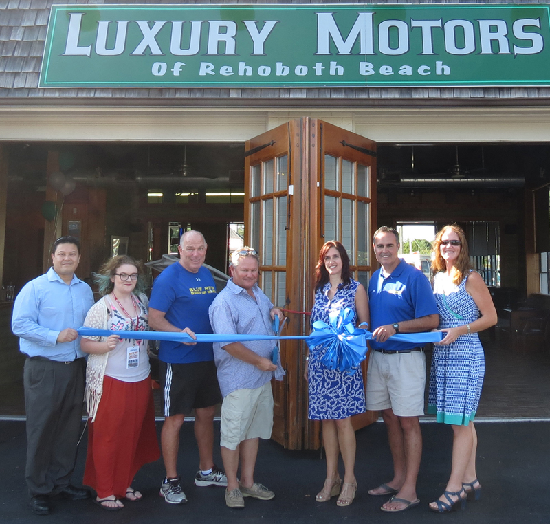 Luxury Motors of Rehoboth Beach cut the ribbon on its new dealership on Coastal Highway. Shown are (l-r) Dan Hallon, Adams Media Group; Leah Rantz, mid-day personality on 93.5 The Beach; Rep. Pete Schwartzkopf, D-Rehoboth Beach; John Ferguson, owner; Kerry Smith, office manager; Sen. Ernie Lopez, R-Lewes; and Meghan McCalley, Rehoboth-Dewey Chamber. SOURCE SUBMITTED
